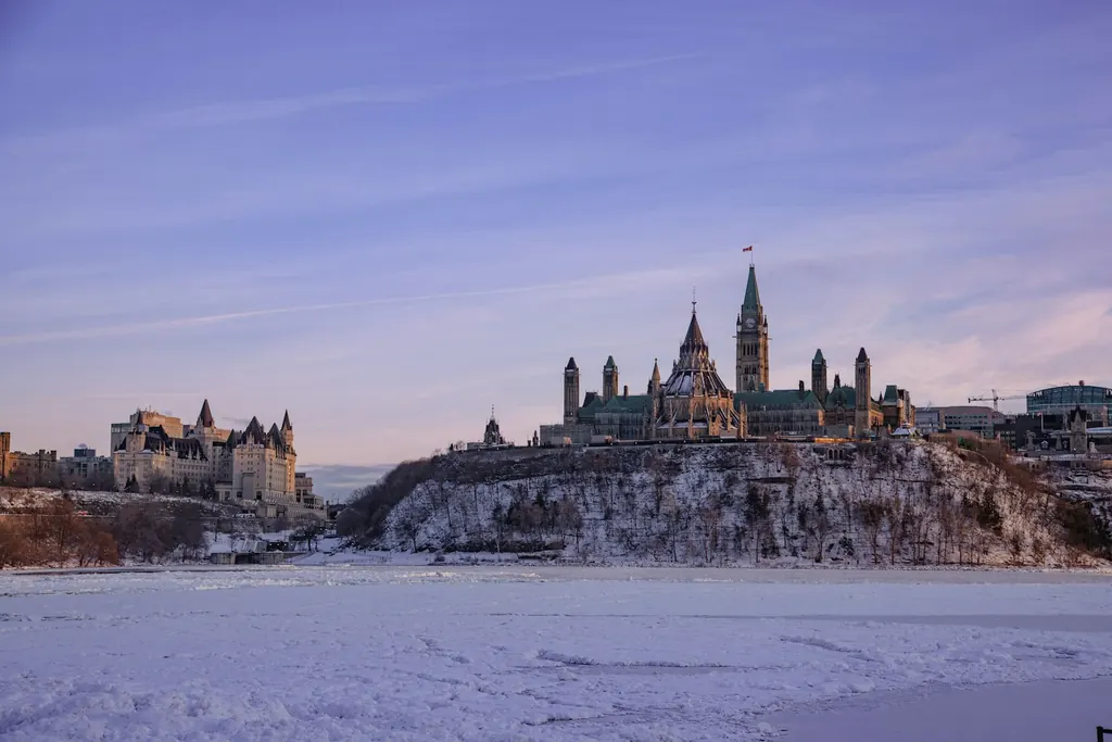 Parliament Hill and the Château Laurier across the frozen Ottawa River at dusk